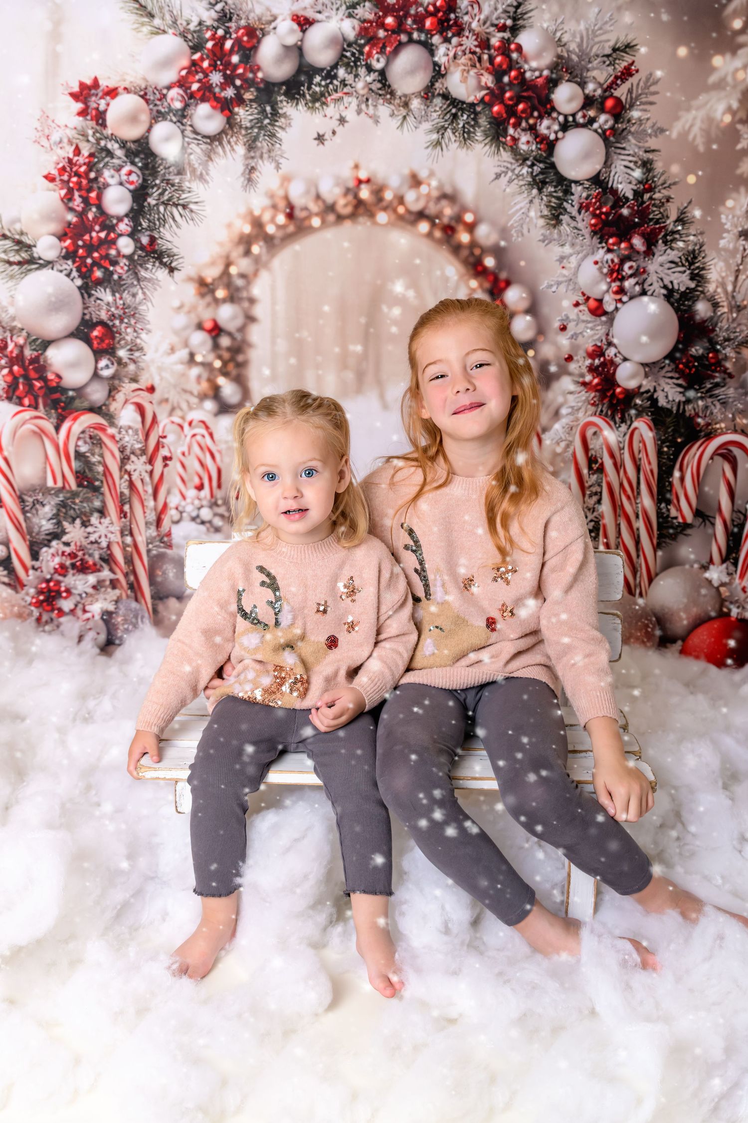 Children sat in the snow at their Christmas Photoshoot with Bear and Bunny Photography