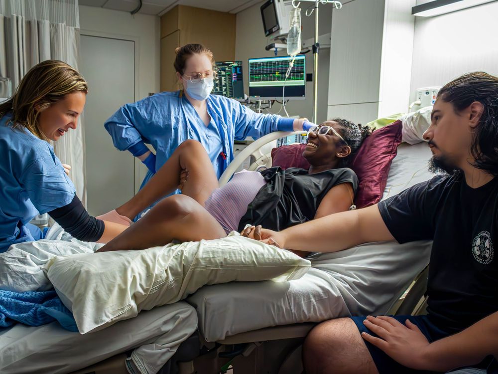 Healthcare providers attending to a patient pushing during labor and delivery.