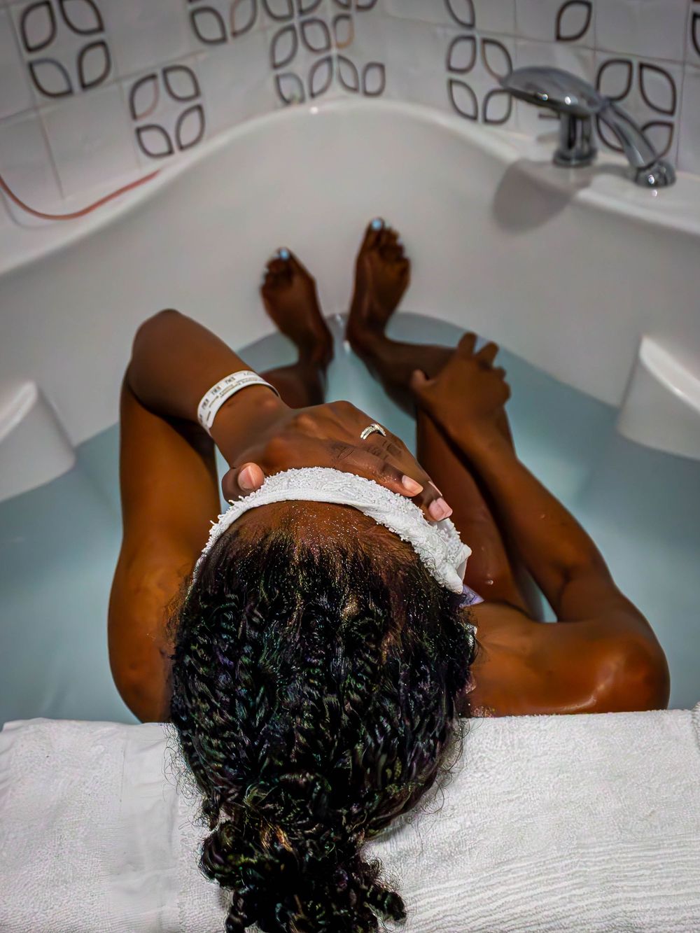 A woman relaxes in a bathtub between contractions.
