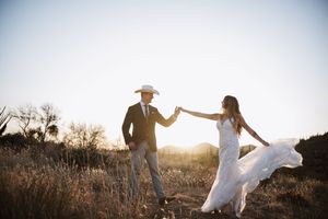 Bride and groom dancing at sunset in the desert.