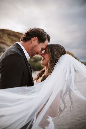 Bride and groom on the beach with a storm brewing in the sky in the background.