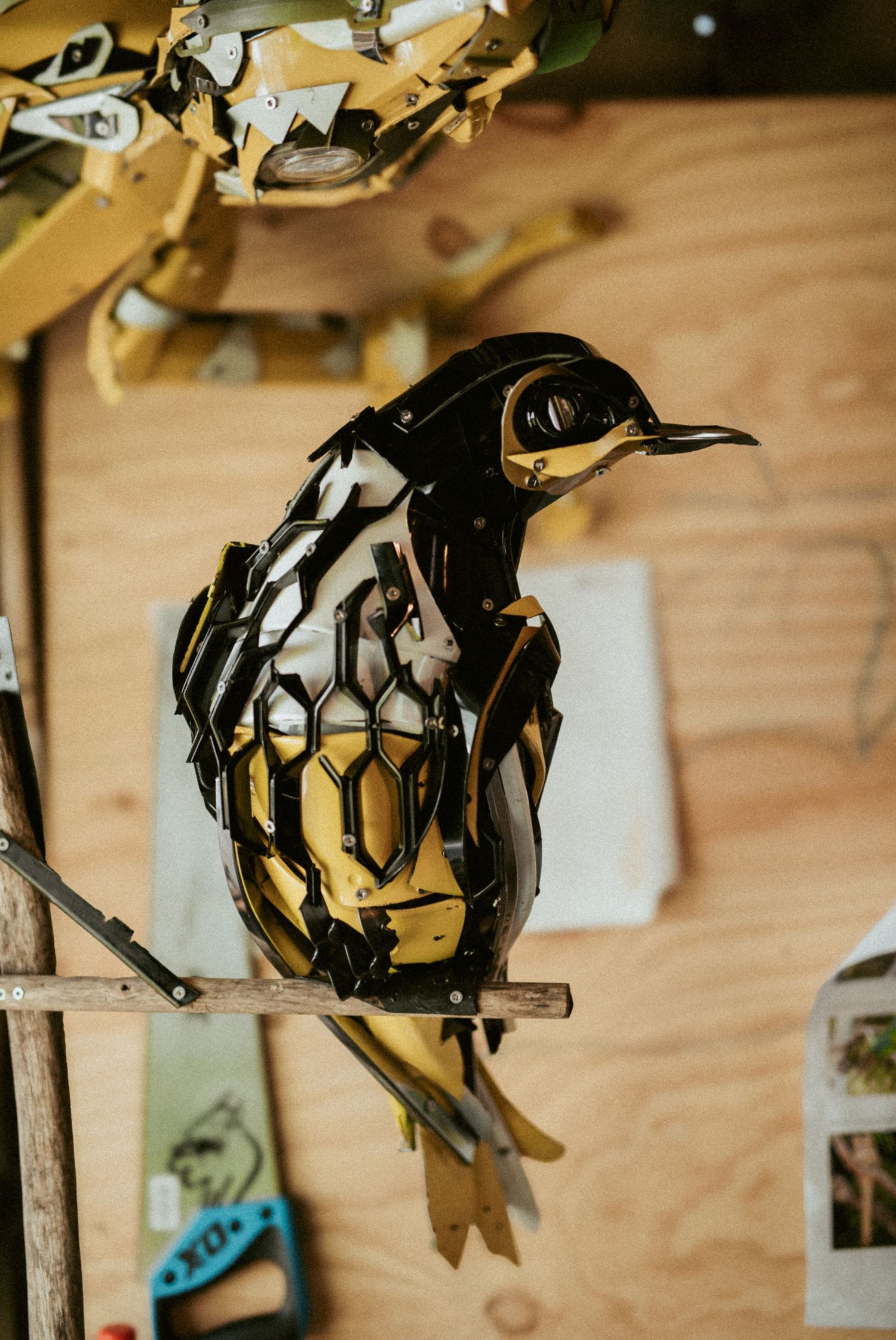 Close-up of intricate metal artwork hanging on wooden wall.