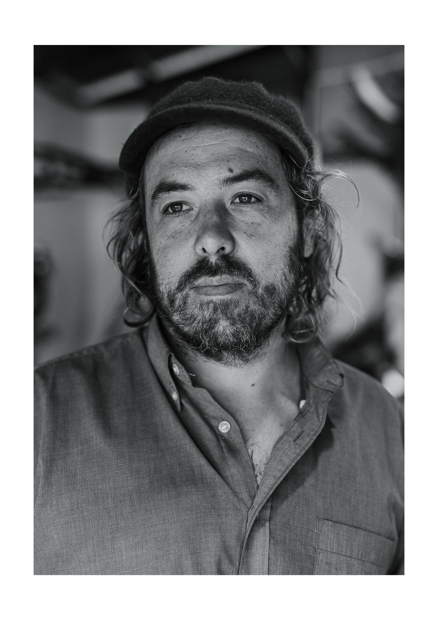 Black and white portrait of an artist in a workshop setting.