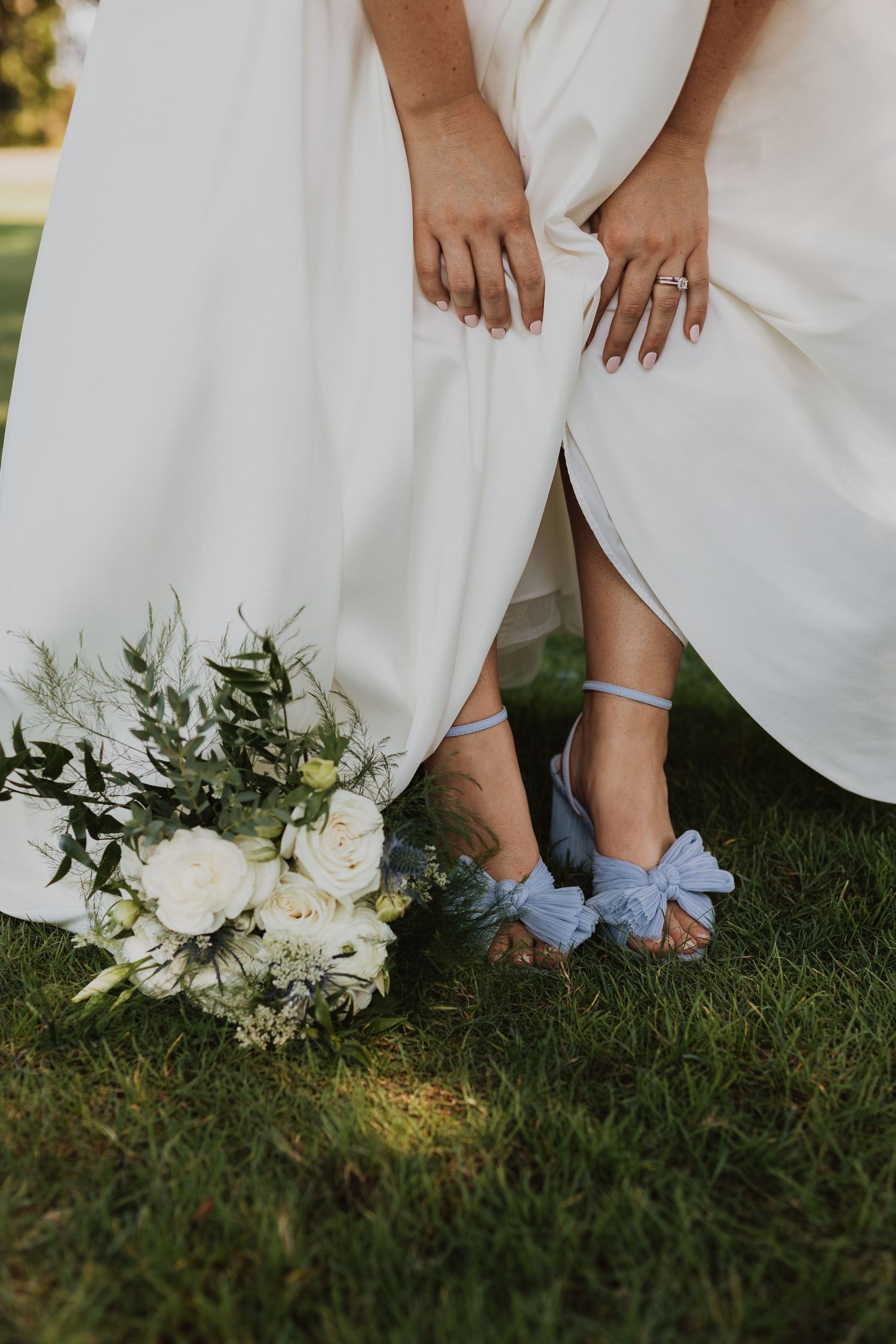 A series of wedding photos showing blue shoes and white dress details with a white floral bouquet on grass.