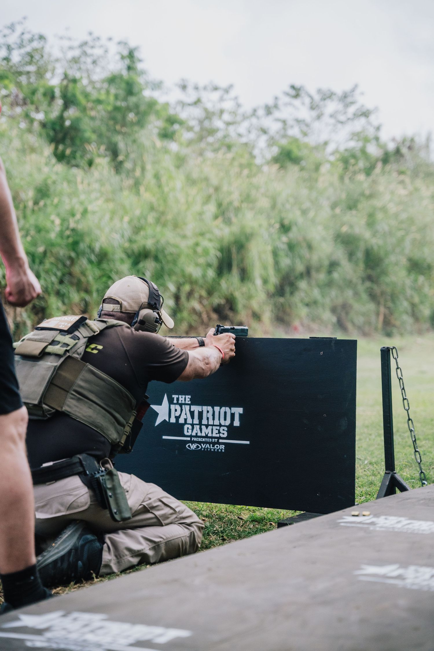 Shooter aims pistol at target during Patriot Games competition.