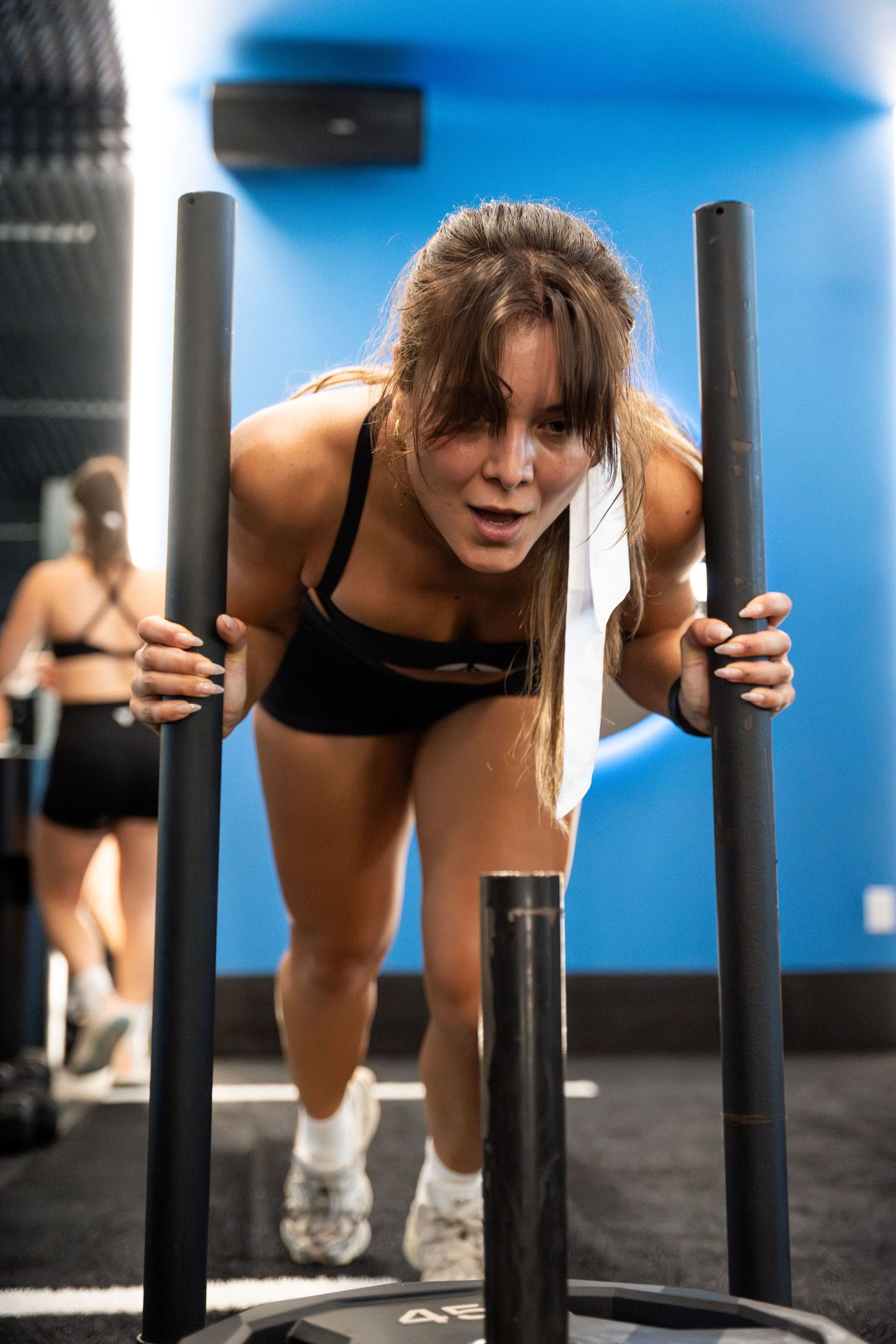 Athlete pushing through a challenging workout using parallel bars in a gym setting.