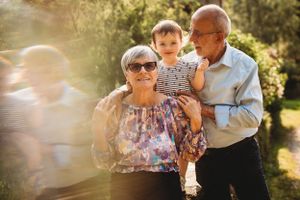 A tender family moment captured in golden sunlight outdoors.