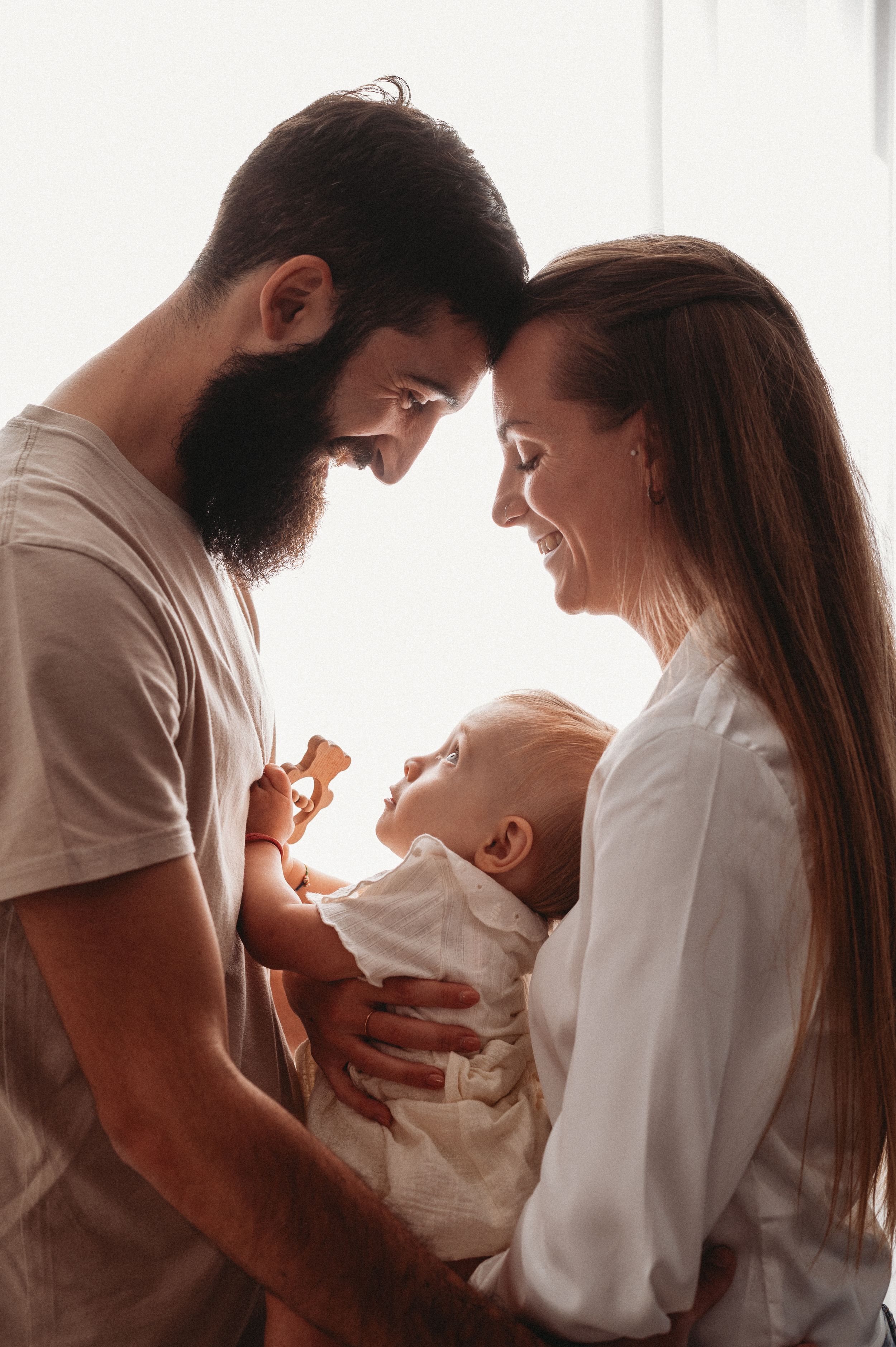 A series of tender moments between a couple and their baby shown in four connected photos at sunset.