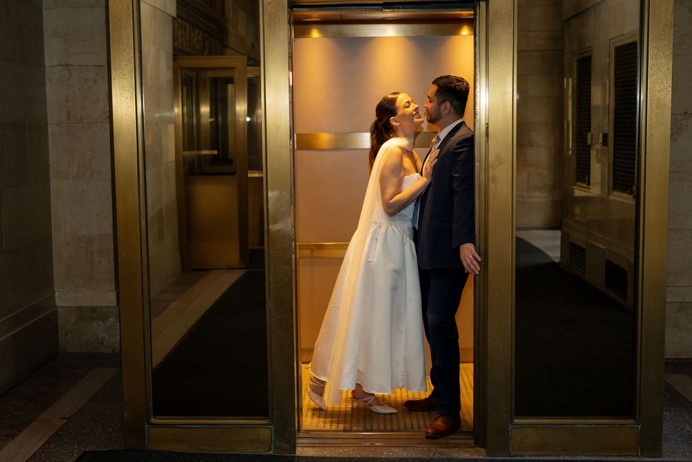 Dramatic indoor wedding portraits in an elegant hallway with moody lighting.