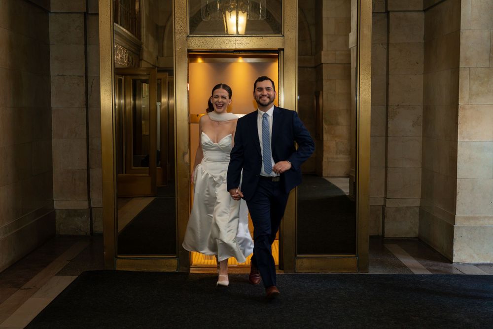 Elegant wedding portraits captured in a grand stone hallway with warm lighting.
