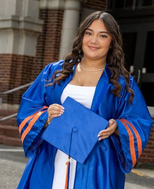 Young woman in blue and orange graduation cap and gown. Salem and Gloucester County Senior Portraits