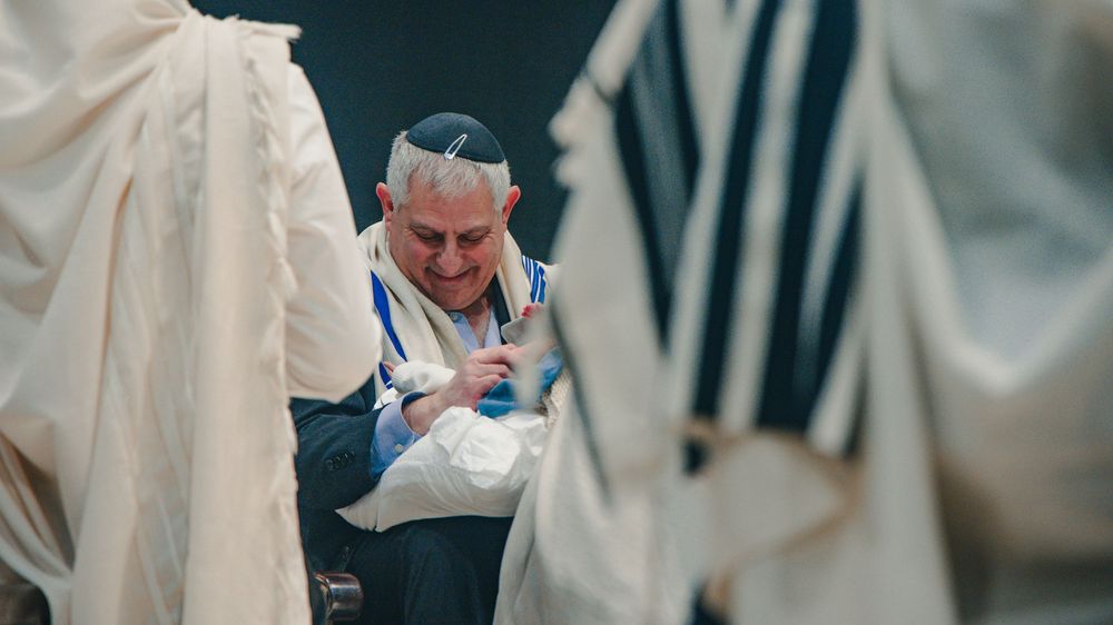 A person in a white chef's coat prepares food in a commercial kitchen setting.