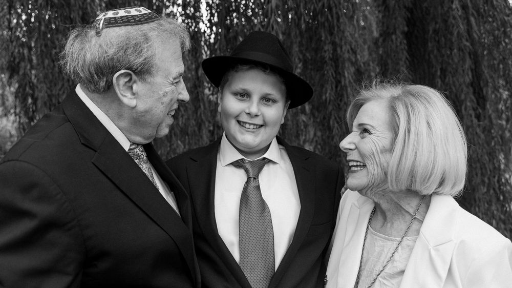 A series of black and white candid wedding photos showing joyful moments between couples and guests at a celebration.