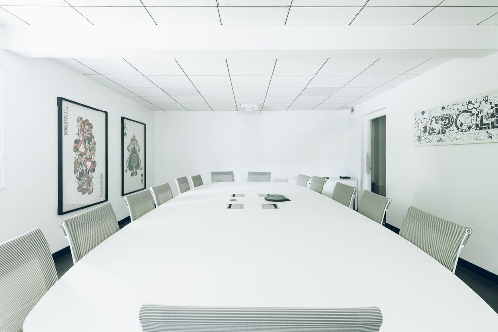 A modern white minimalist medical clinic interior with mounted displays and framed artwork on the walls.