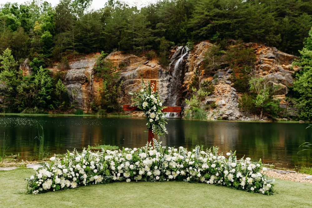 Elegant outdoor wedding ceremony setup with white floral arch at Waterstone Venue in Johnson City, TN.
