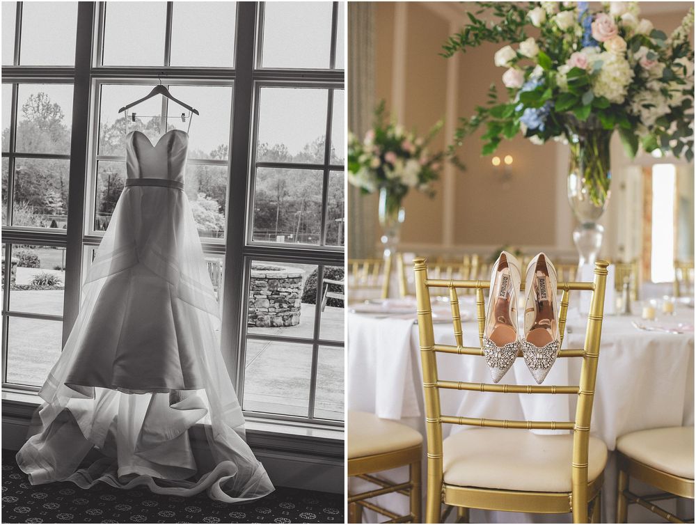 A wedding dress hangs by a window next to elegant gold chairs and floral centerpieces at a reception venue.