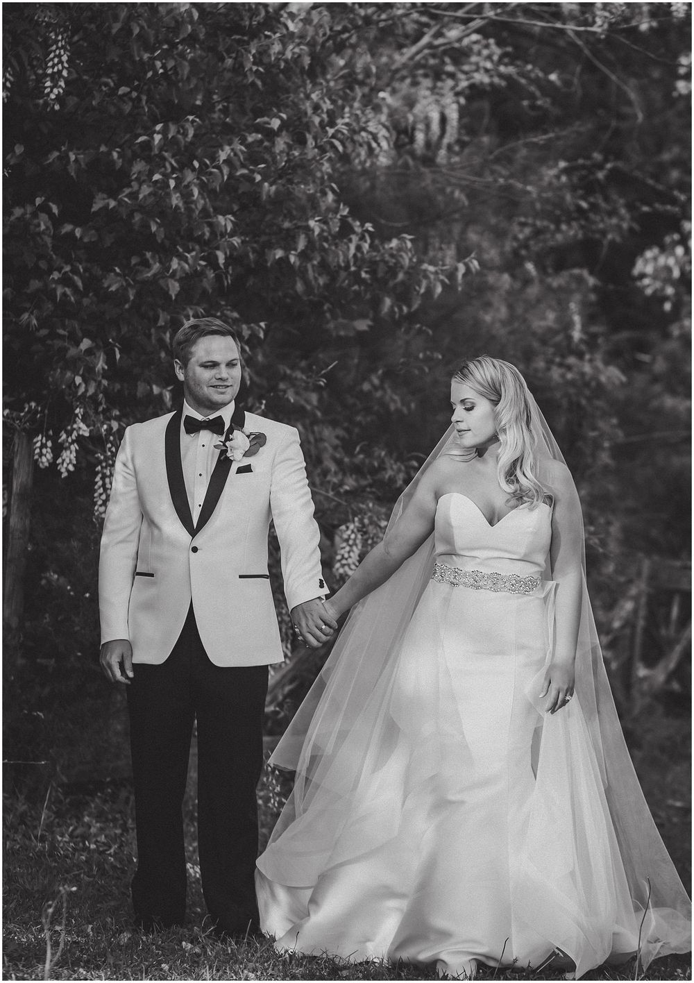 Black and white wedding photos show a romantic moment between newlyweds in a garden setting.