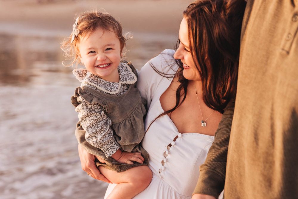 Family shares joyful candid moments together outdoors during golden hour photoshoot.