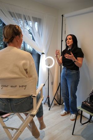 Multiple frames showing a photo shoot setup with lighting equipment and a director's chair in a bright studio space.