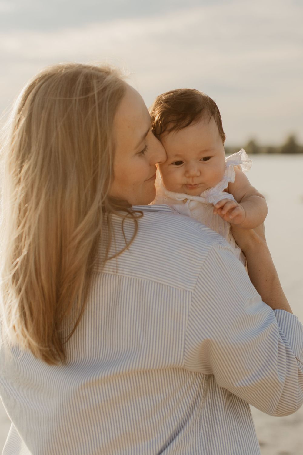 A series of intimate moments between parent and baby against a soft sunlit backdrop during golden hour.