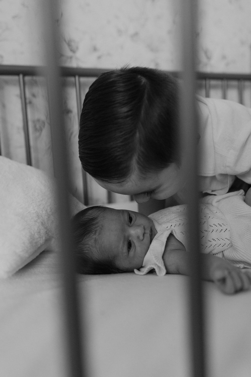 A person sleeps peacefully in bed viewed through vertical bars.