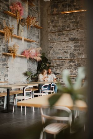 A cozy cafe interior with exposed brick walls and dried flower decorations.