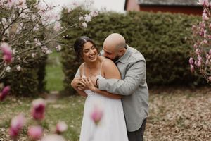 Couple shares intimate moments among blooming cherry blossoms in a romantic spring wedding photoshoot.