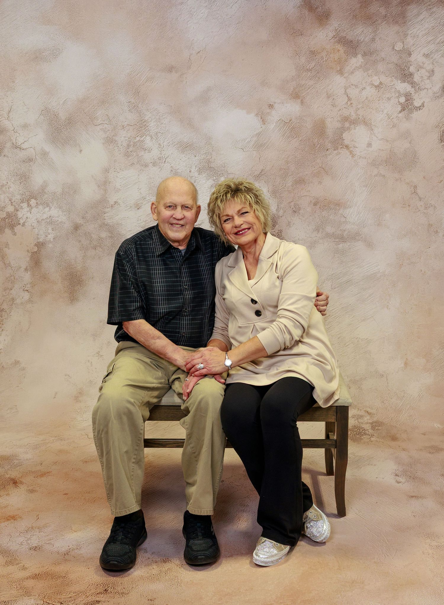 Elderly couple sitting together and sharing affectionate moments in a series of casual studio portraits.