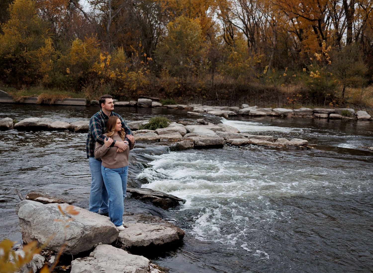 A series of photos showing someone photographing a rushing river from various angles along rocky banks in autumn.