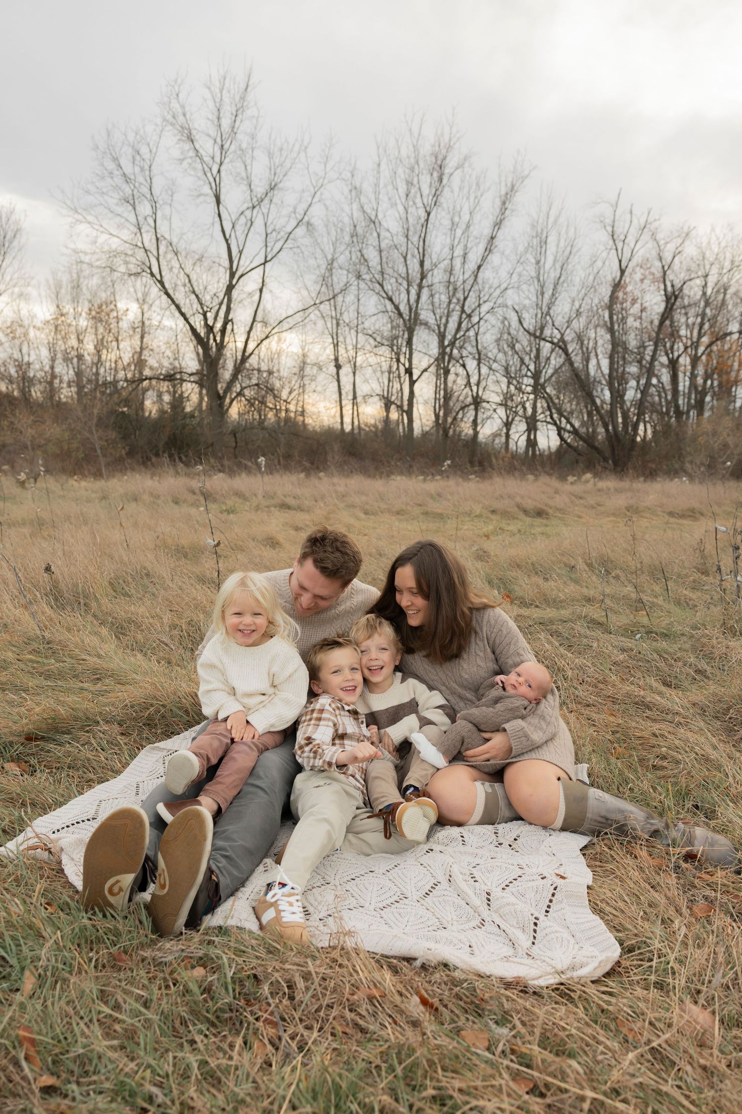 brother and sister sitting on a wooden log for a photo at troy farm park in Oakland county michigan