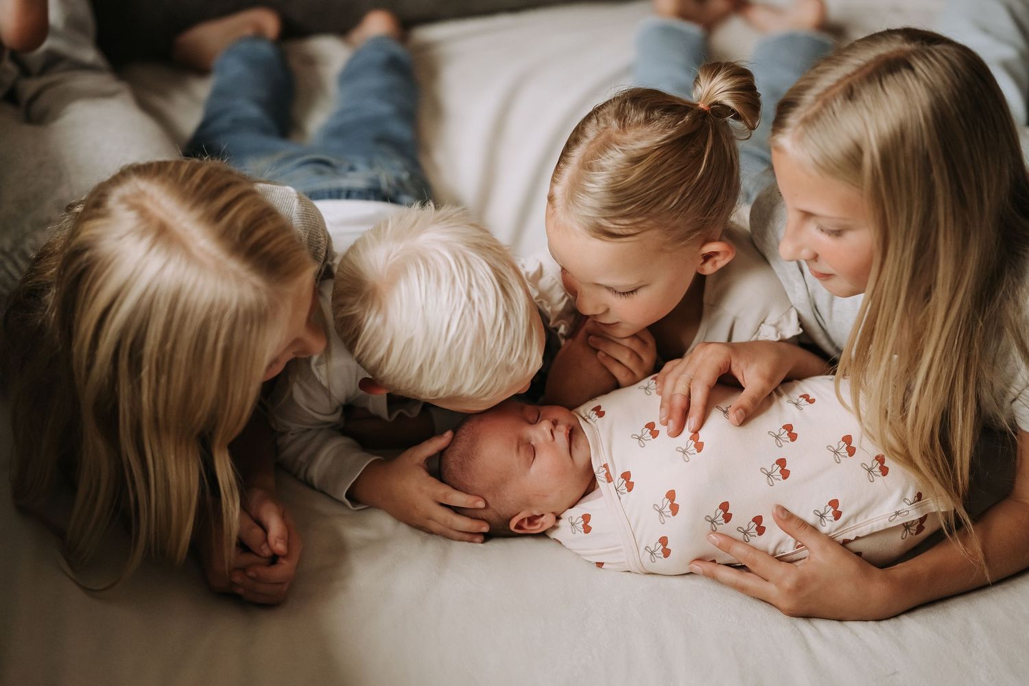 Family members lying together on bed sharing intimate moment.