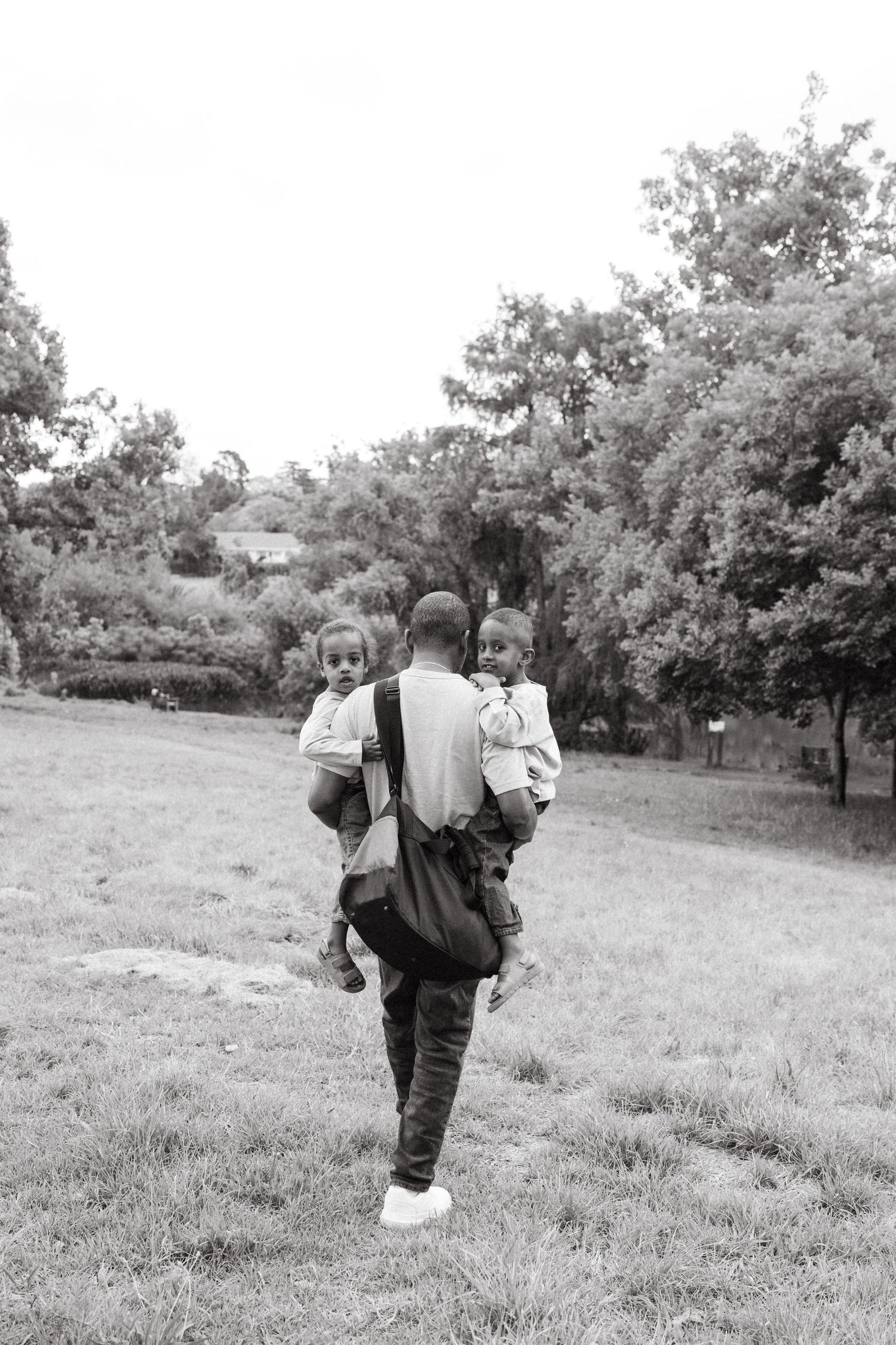 Black and white photos showing figures walking across a grassy hillside.