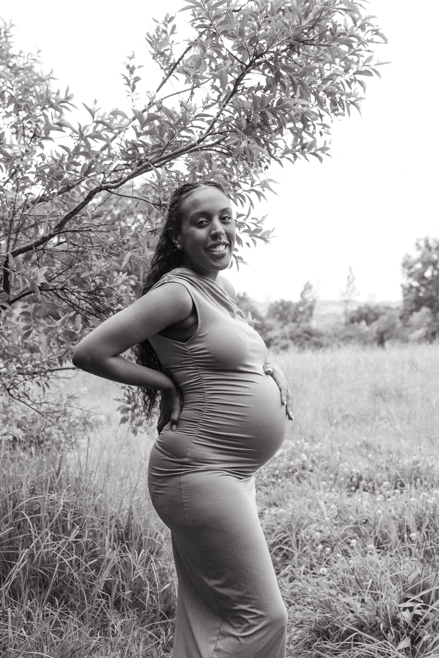 A sequence of photos showing a pregnant woman posing in a natural outdoor setting.