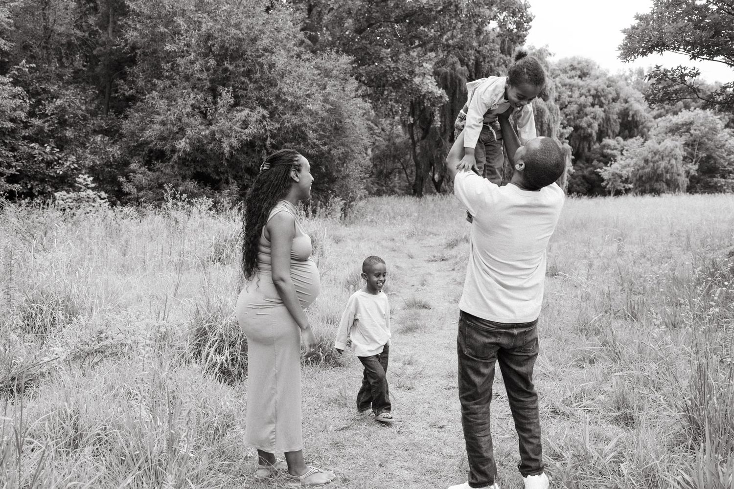 Black and white images of a family spending time together in a natural setting.