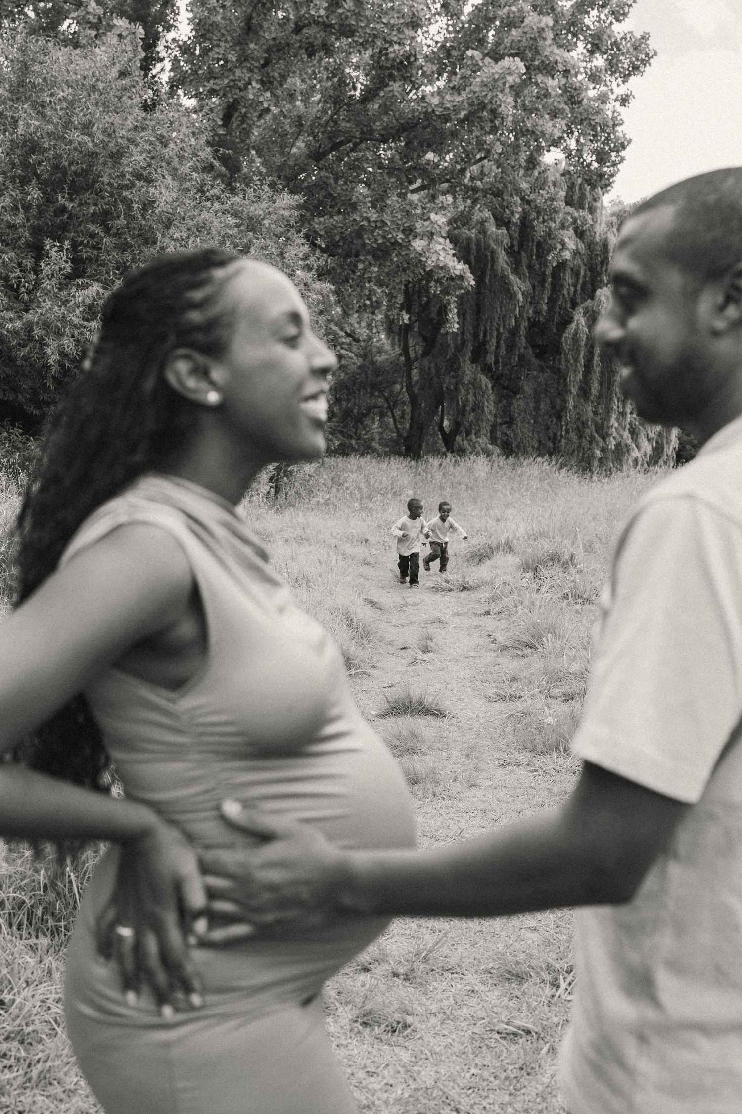 Black and white sequence showing playful interaction between two people in a meadow.