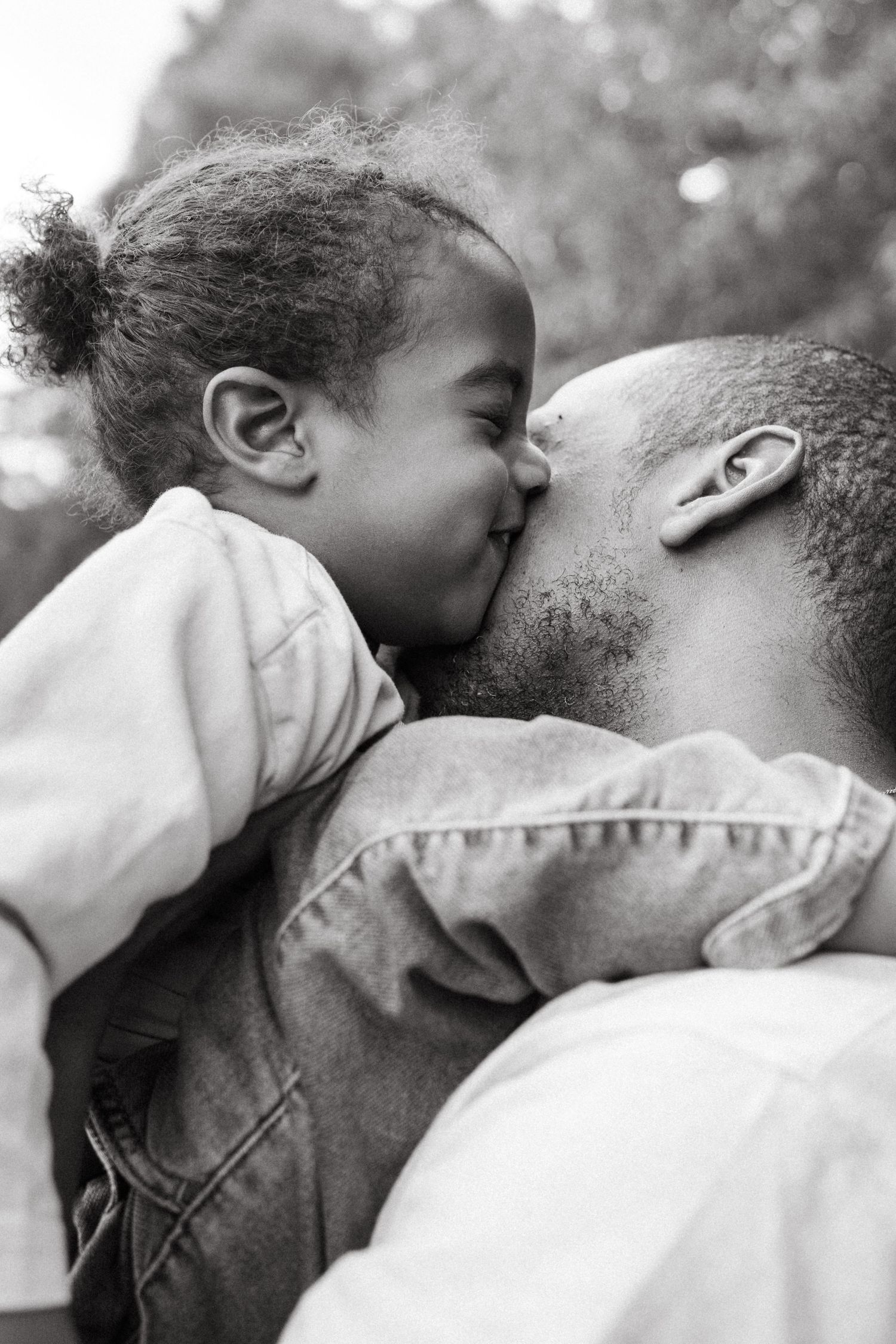 Close-up black and white portrait showing affectionate family embrace.