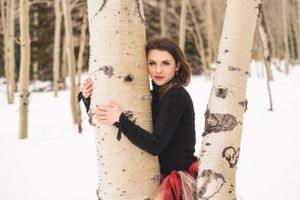 Winter portrait session among snow-covered aspen trees.
