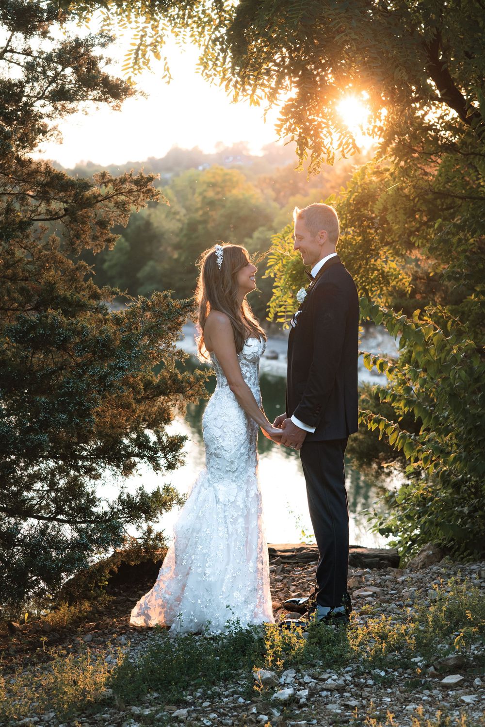 Romantic sunset wedding photos by lakeside with golden light filtering through trees.