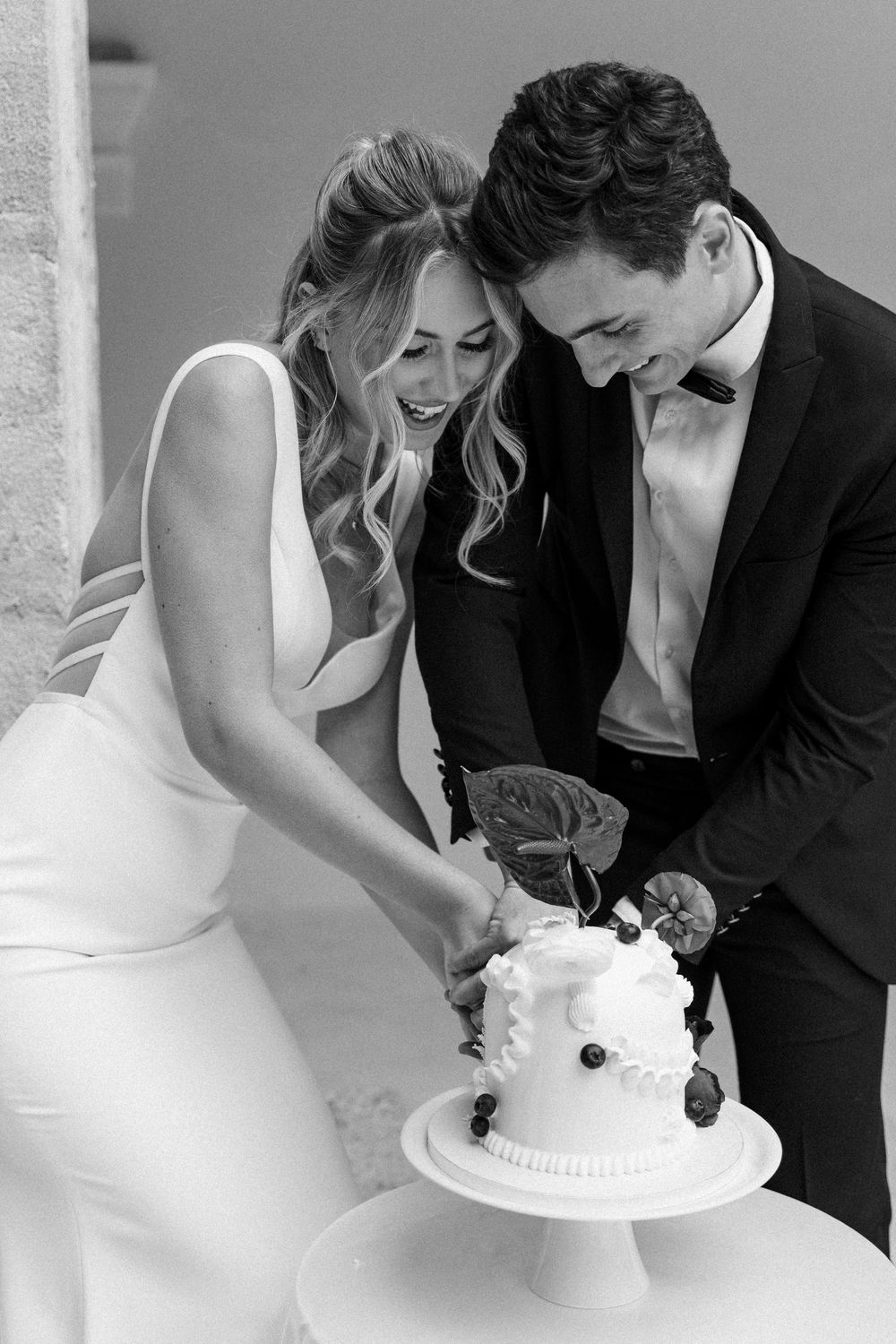 Black and white photo sequence showing couple cutting their white wedding cake together at reception.