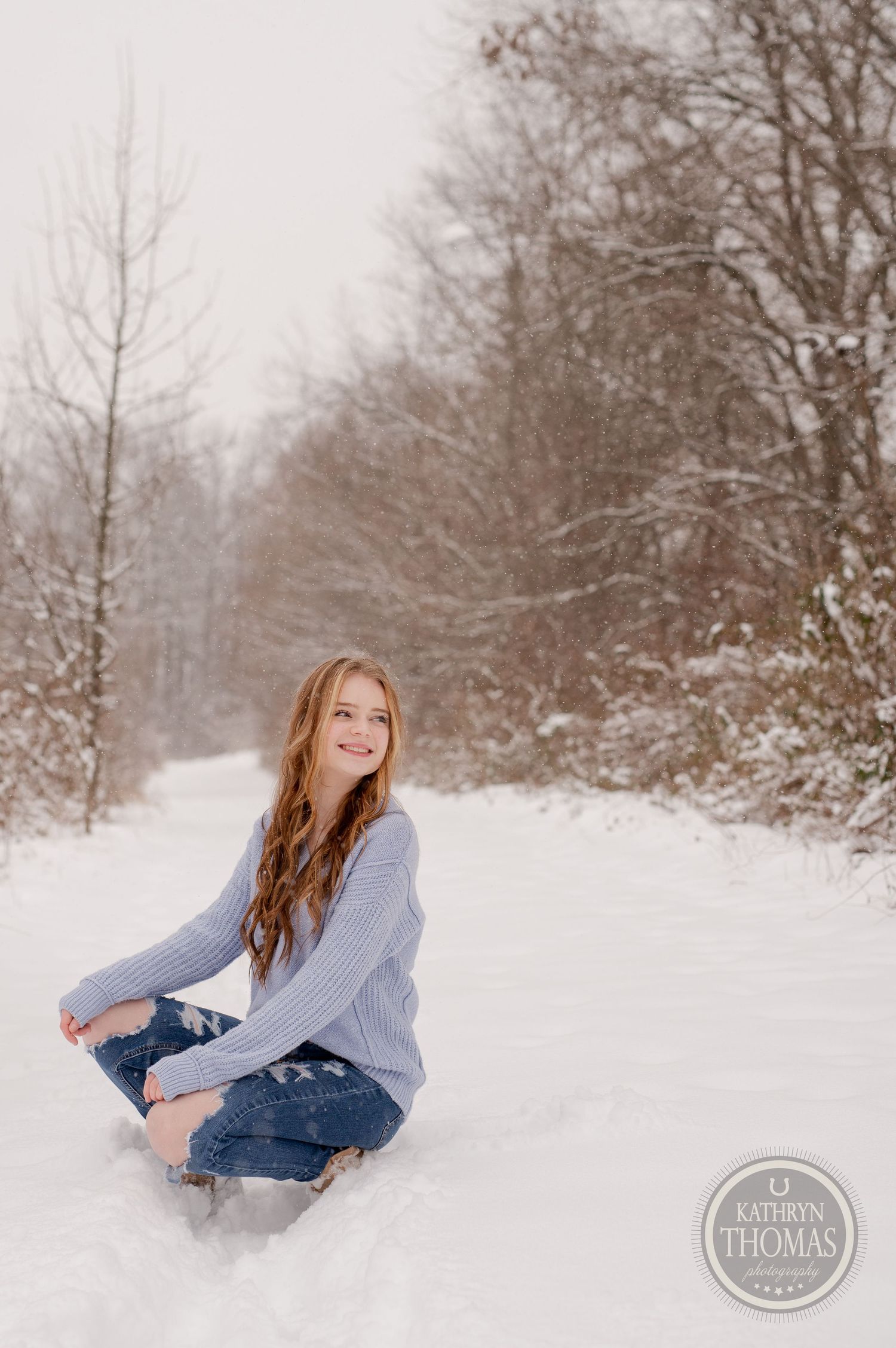Lifestyle portrait in a snowy forest setting with casual winter fashion.