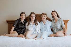 Bride and her bridesmaids in matching pajama set getting ready at a Fredericton hotel by light & airy wedding photographer in New Brunswick