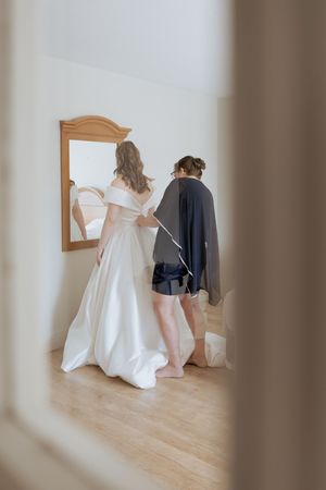 Bride and mother getting ready into wedding dress New Brunswick wedding photographer editorial fine art wedding photography candid moment