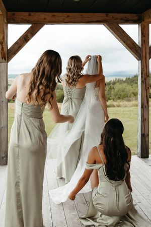 bridesmaids help bride into wedding dress adjust veil at Hopewell Highlands editorial fine art wedding photography New Brunswick classic