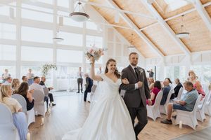 Bride and groom walking down ceremony aisle after wedding ceremony at a bright and airy wedding venue in New Brunswick, Canada wedding photo