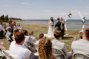 bride and groom exchange vows during beach front wedding ceremony in Nova Scotia, full sun afternoon wedding photography Halifax NS