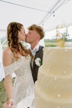 bride and groom kiss during outdoor summer tent wedding in Nova Scotia wedding photographer, intimate wedding photography