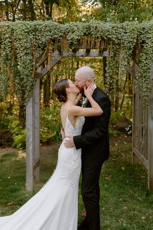 Bride and groom's first kiss wedding ceremony outdoor fall wedding in New Brunswick, Farmer Brown's Greenhouse wedding in Moncton