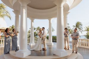 Bride and groom first kiss wedding ceremony beach resort overlooking the ocean at sunset Mexico wedding photographer from Canada gazebo