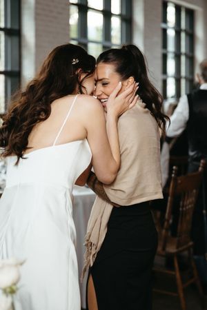 bride and maid of honour share candid moment during intimate wedding at Tire Shack Brewery, Moncton wedding photography in New Brunswick