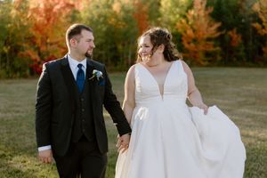 Bride and groom hold hands and walk at sunset fall wedding photography portraits in Moncton New Brunswick, The Grand Ivory wedding